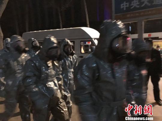 十几名身着防护服的人员头戴面具进入事发地。　胡健 摄